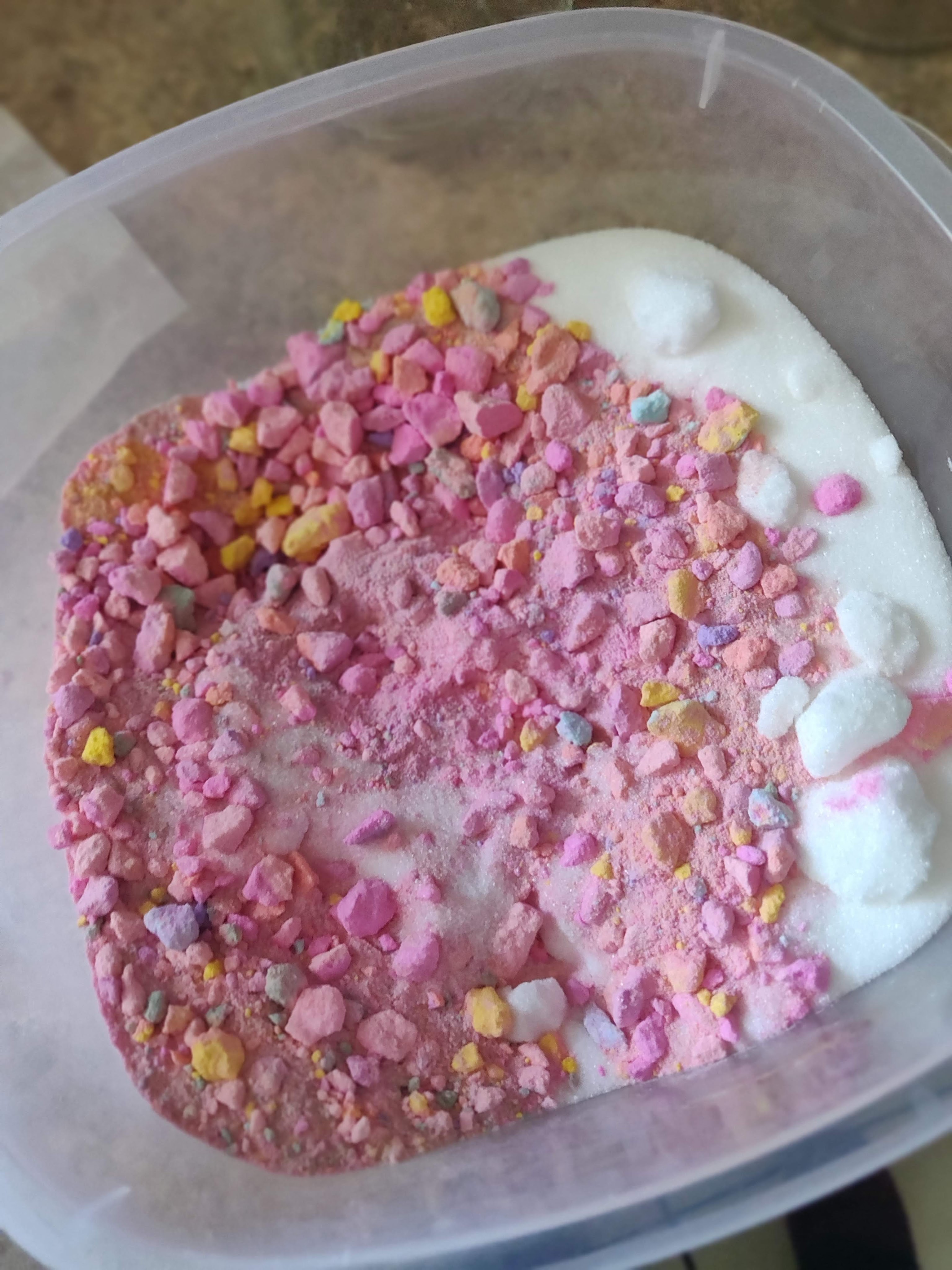 Crumbled bath bomb and sugar combined in a plastic container.
